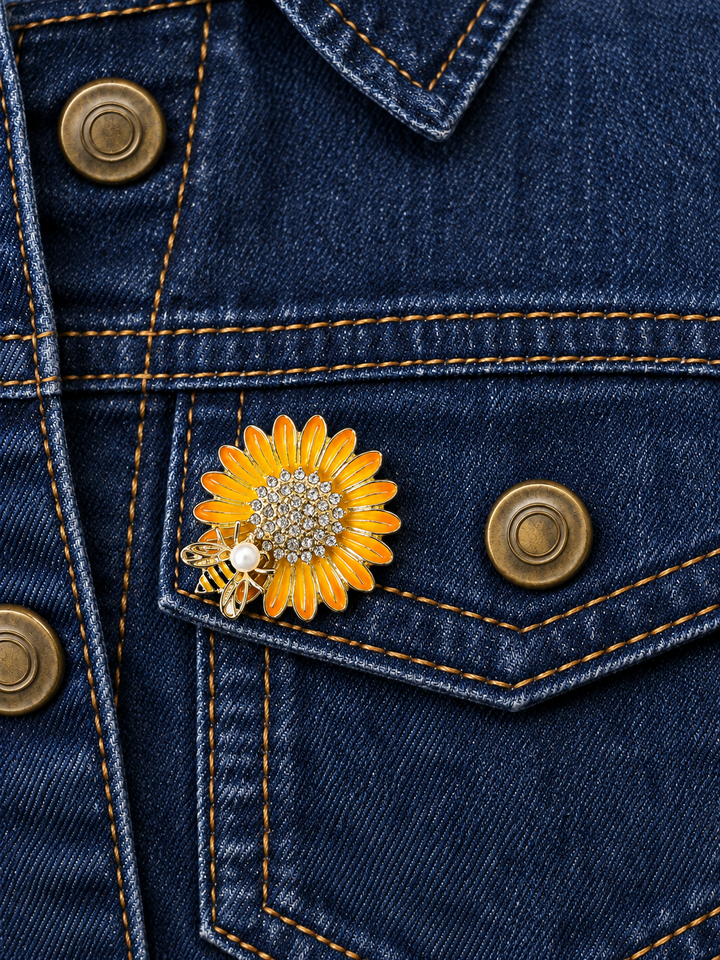 Rhinestone Sunflower Bee Pin displayed on dark indigo denim beside an antiqued brass button