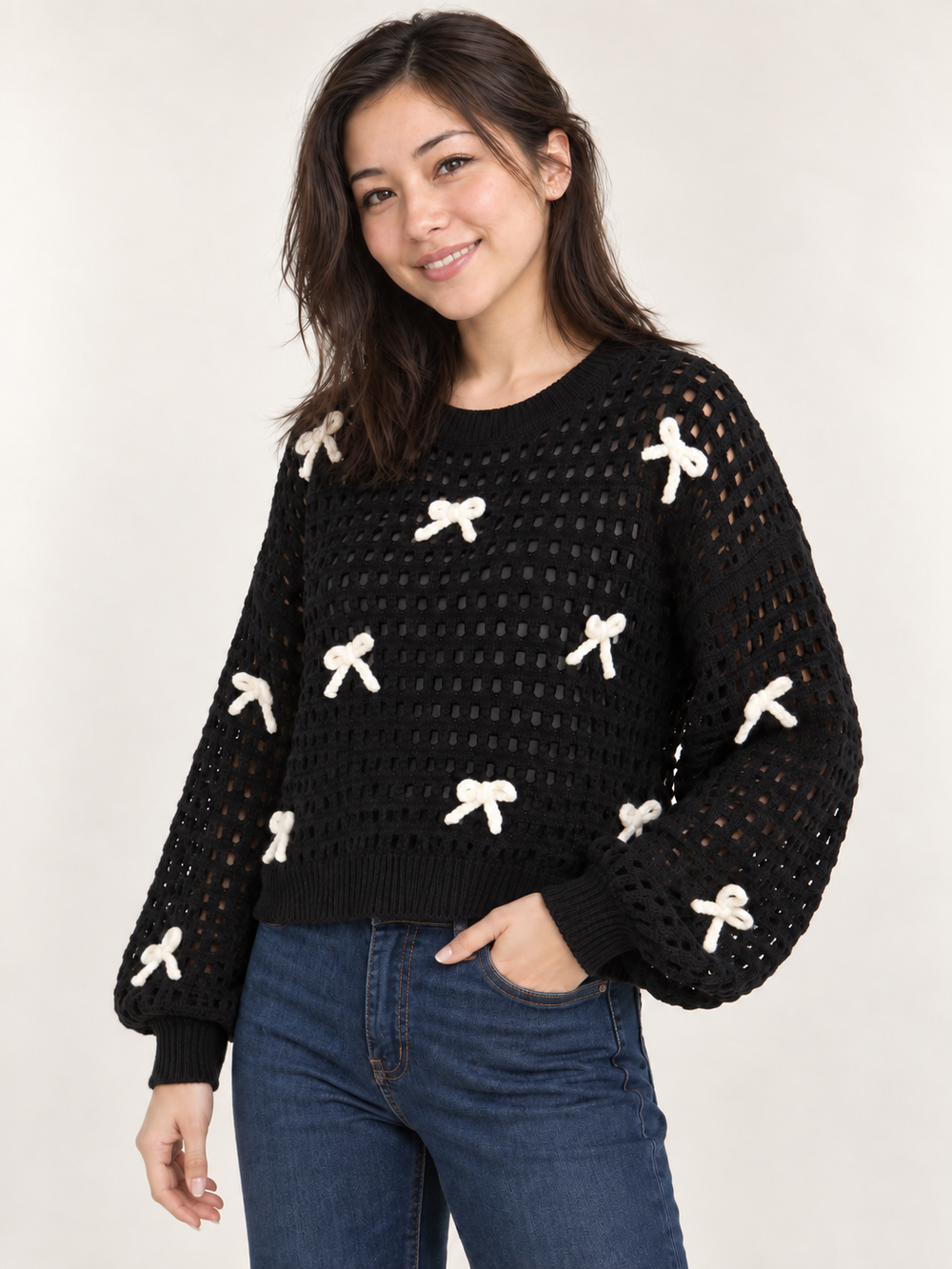 Model wearing black ribbon open-knit sweater, angled view