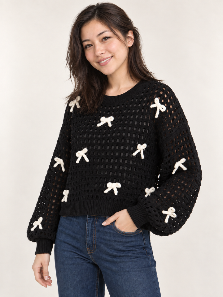 Model wearing black ribbon open-knit sweater, angled view