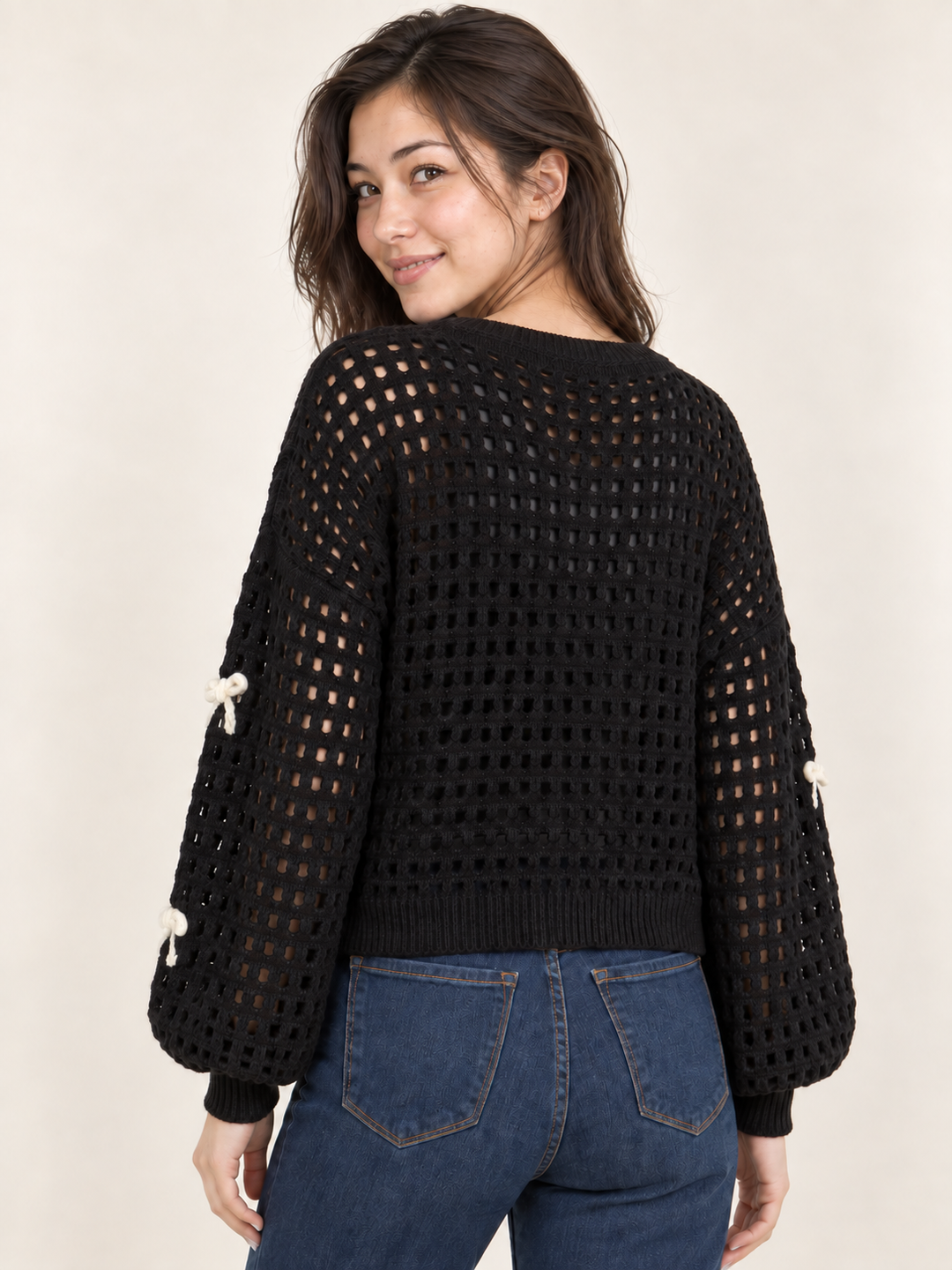 Model wearing black ribbon open-knit sweater, back view