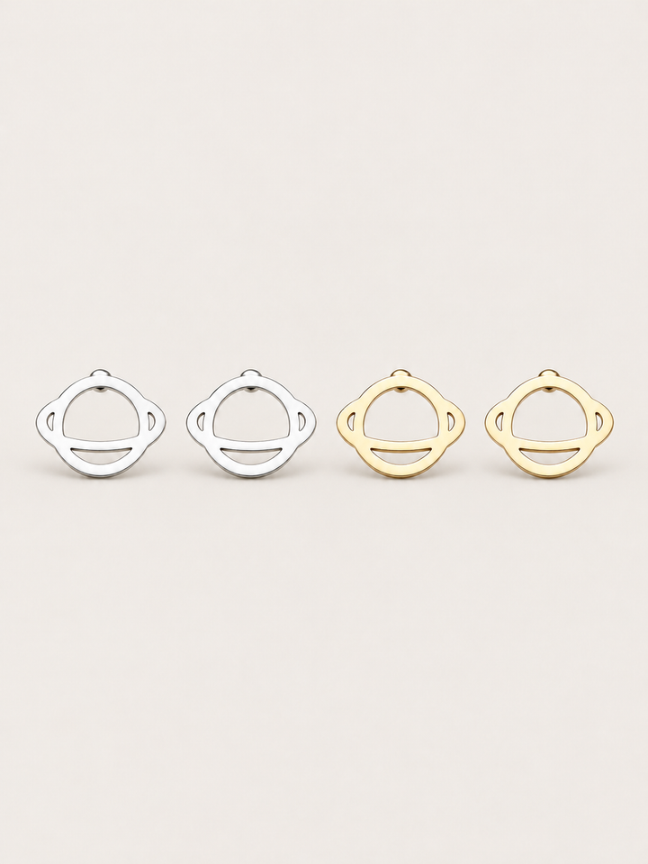 Ringed Planet Stud Earrings in silver and gold on a warm neutral background