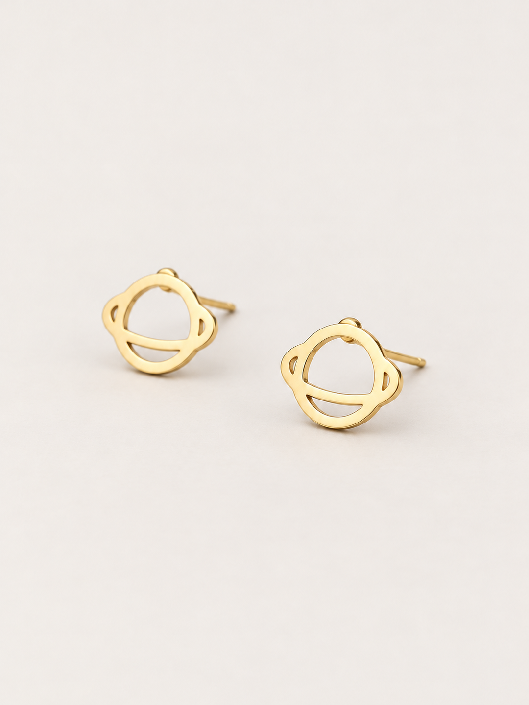 Ringed Planet Stud Earrings gold angled view on a warm neutral background