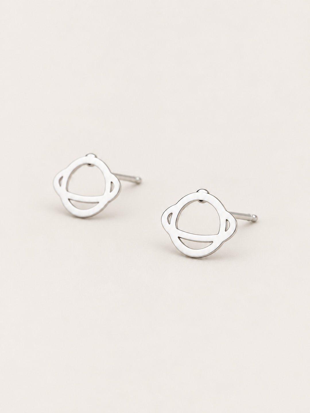 Ringed Planet Stud Earrings silver angled view on a warm neutral background