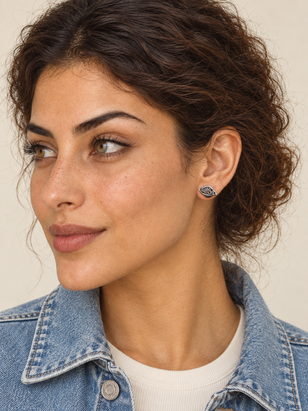 Model wearing the silver ringed planet stud on the viewer-right ear