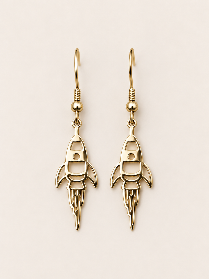 Gold Rocket Drop Earrings on a warm neutral background
