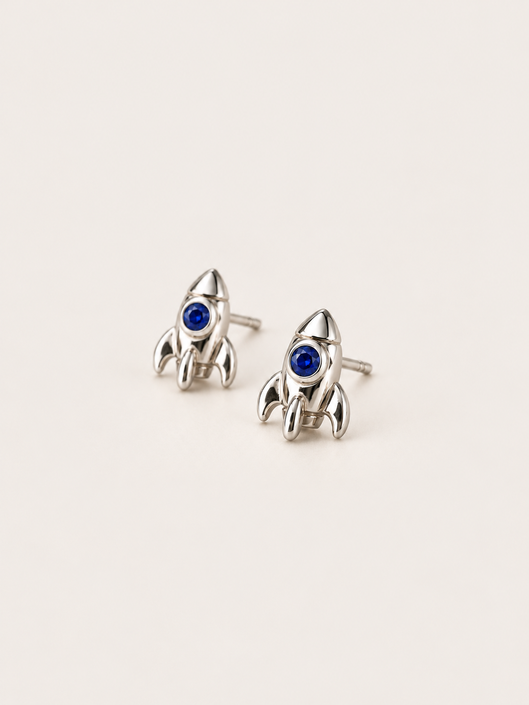 Rocket Stud Earrings in Silver shown angled on a warm neutral background