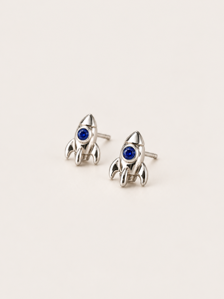 Rocket Stud Earrings in Silver shown angled on a warm neutral background