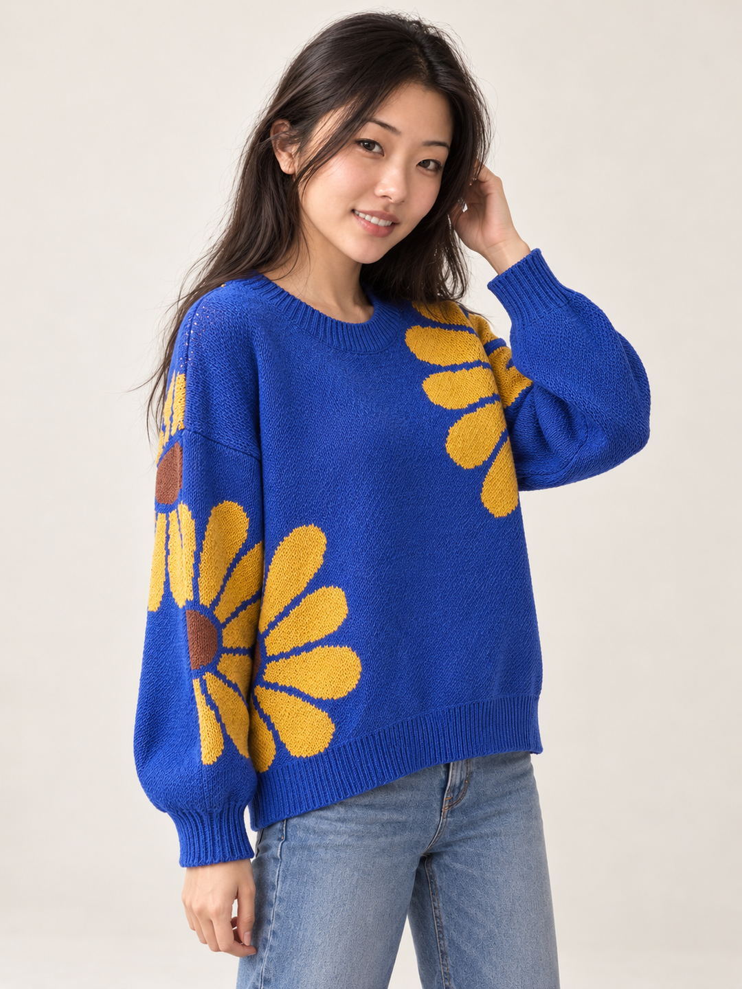 Angled view of royal blue daisy knit sweater and dropped shoulders
