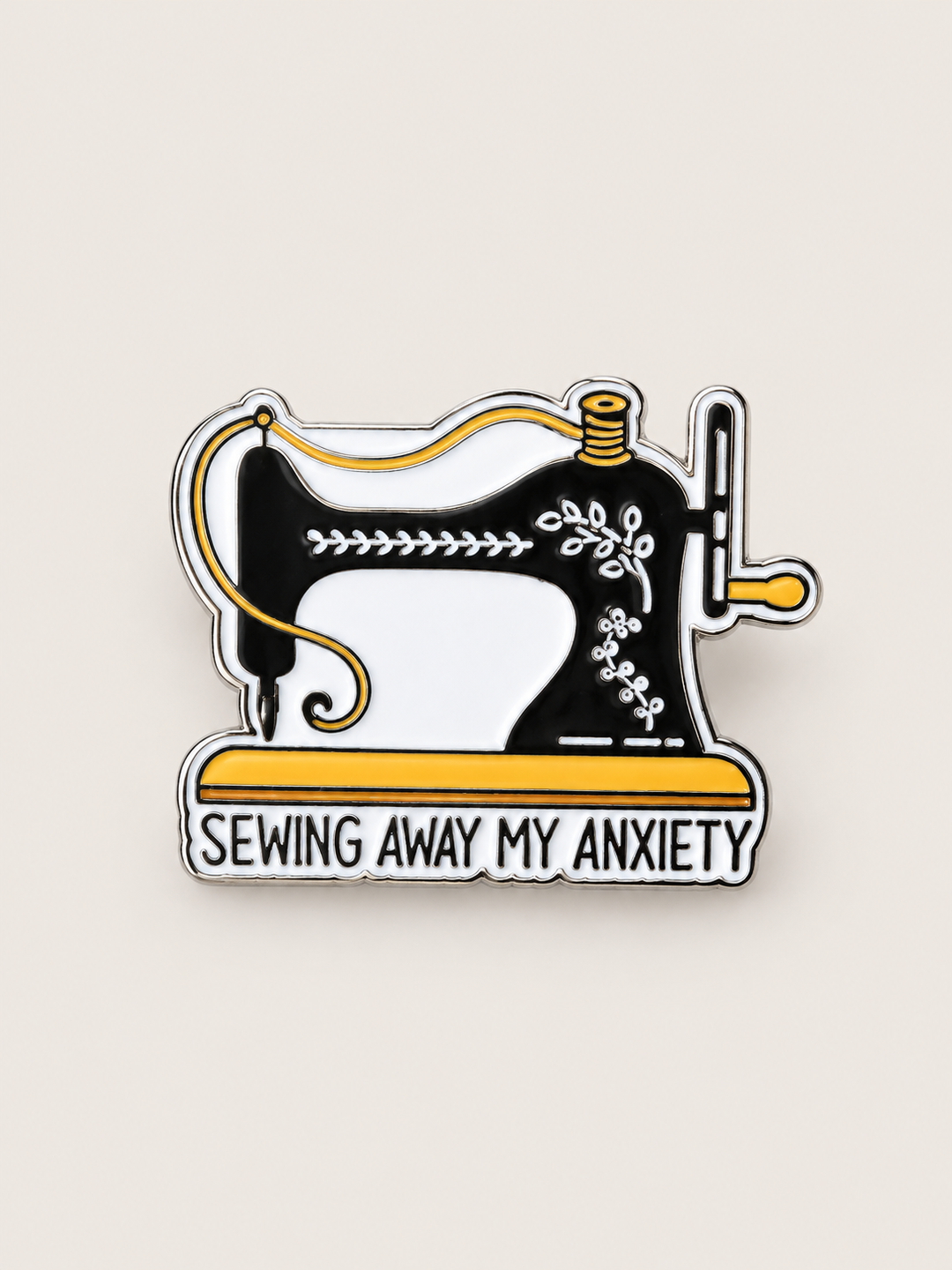 Sewing Away My Anxiety Sewing Machine Pin shown on a warm neutral background