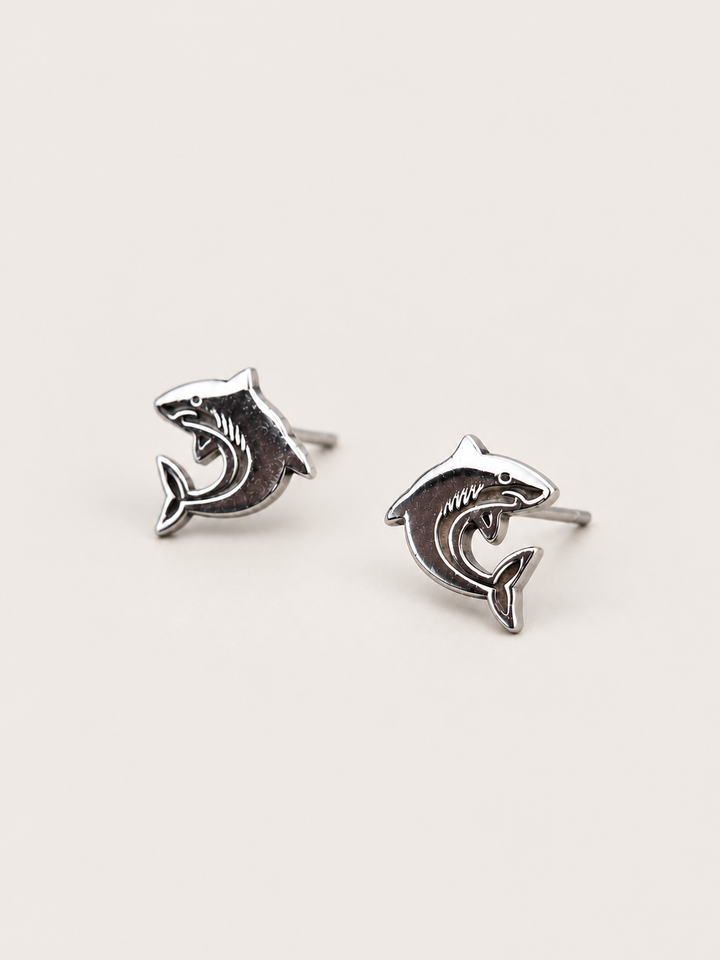 Shark Stud Earrings shown angled on a warm neutral background