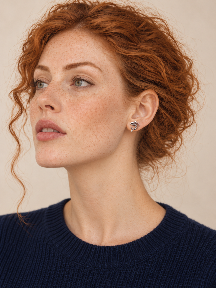Silver stainless steel Shark Stud Earrings worn by a model in a dark blue sweater