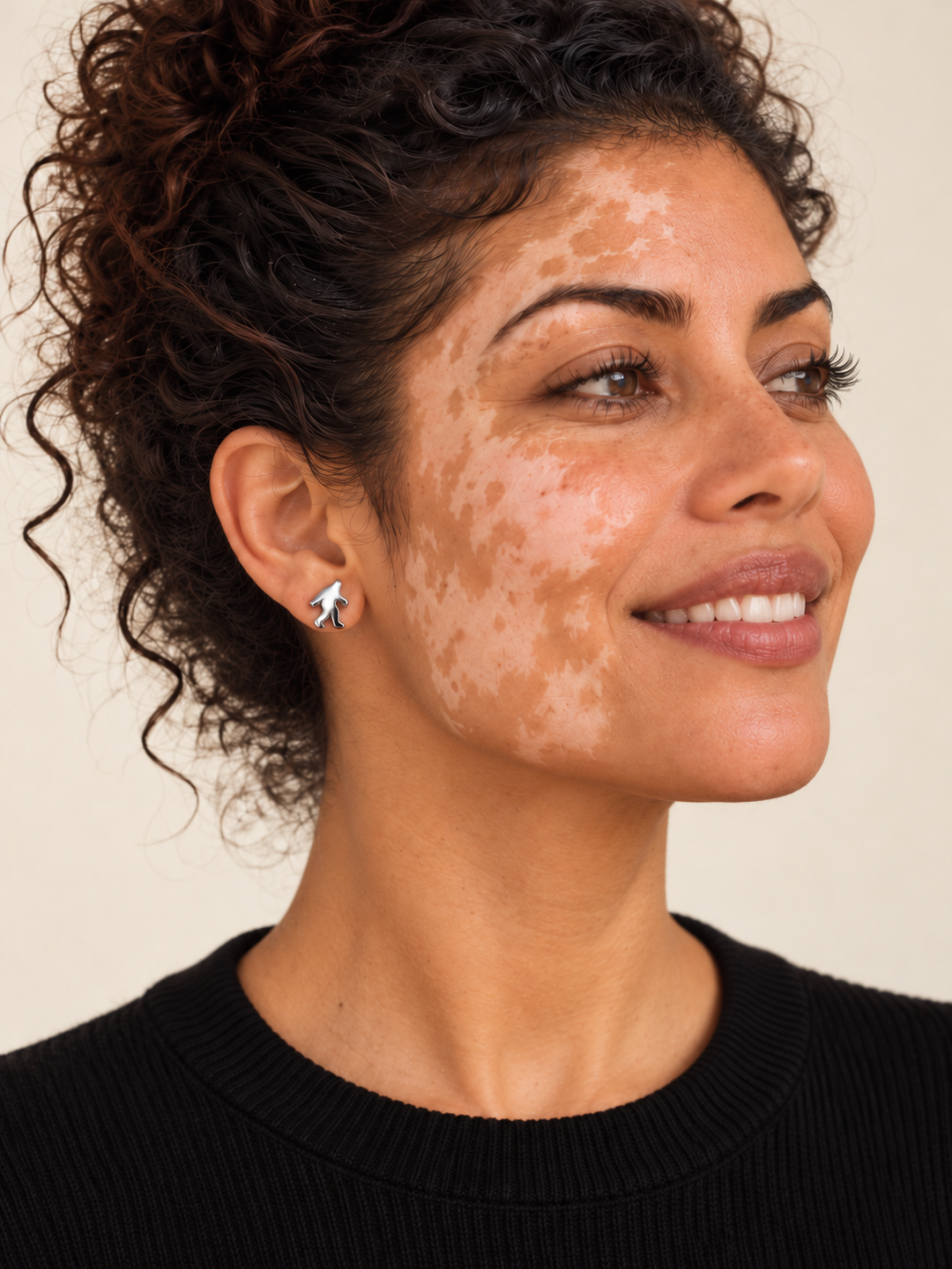 Model smiling while wearing a silver stainless steel Bigfoot stud earring