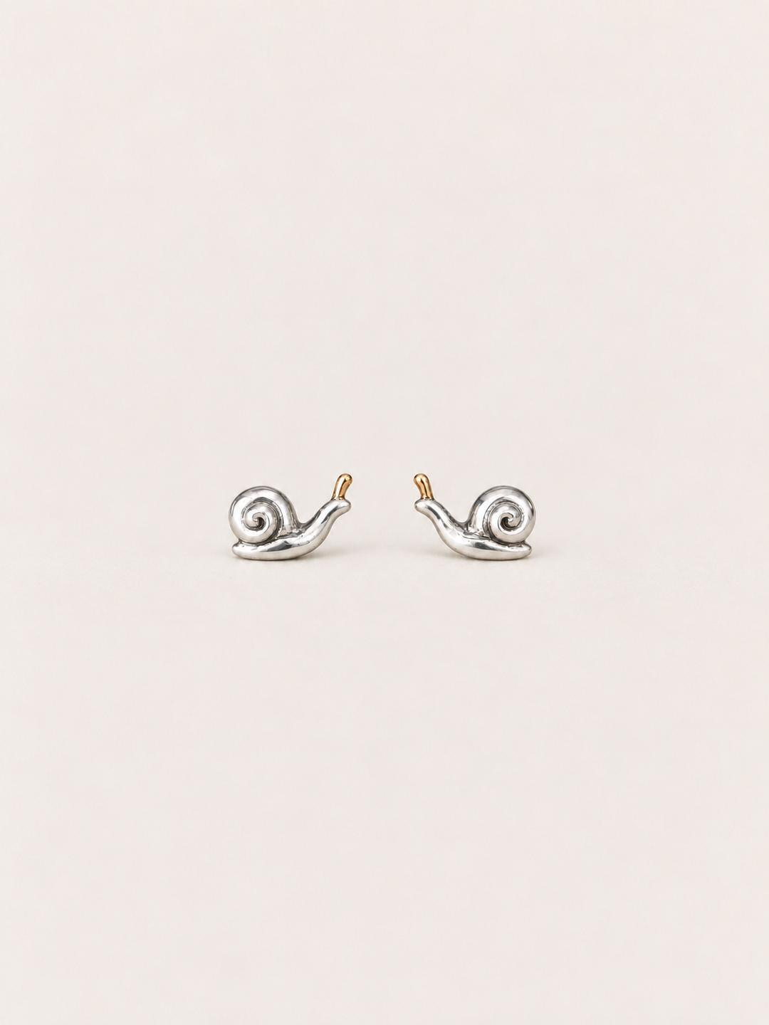 Snail Stud Earrings shown on a warm neutral background
