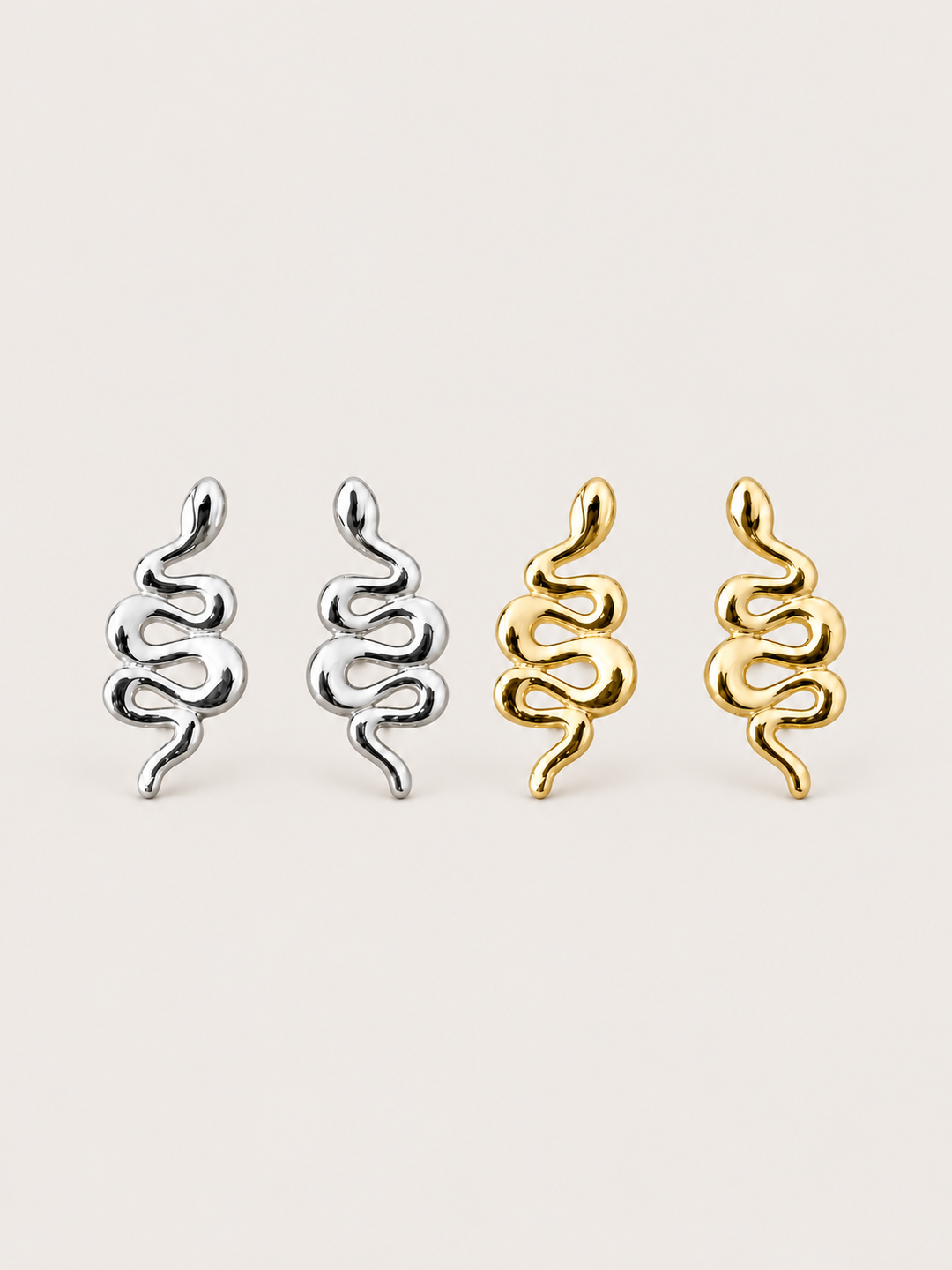 Snake Stud Earrings in silver and gold shown on a warm neutral background