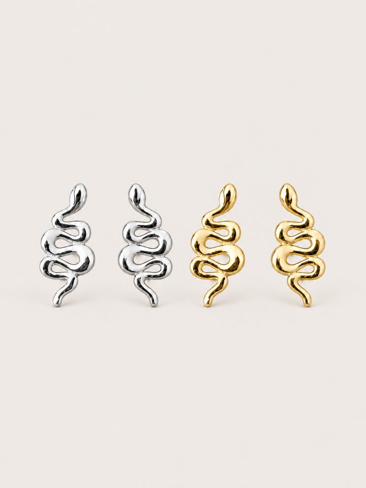 Snake Stud Earrings in silver and gold shown on a warm neutral background