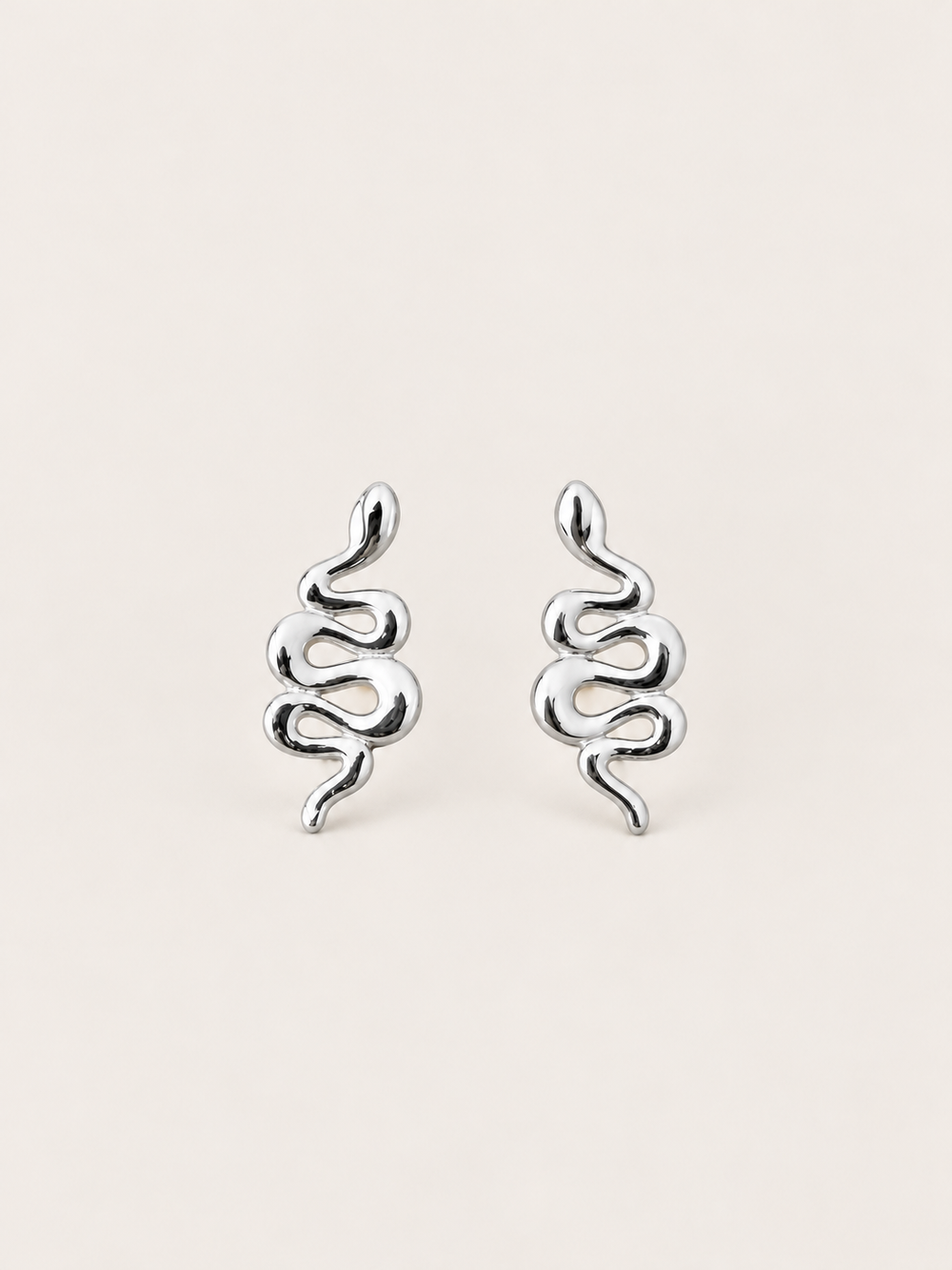 Silver Snake Stud Earrings shown on a warm neutral background