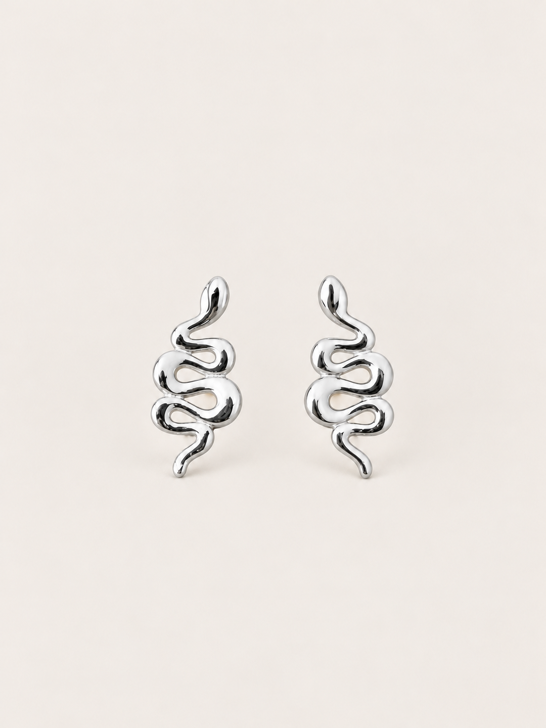 Silver Snake Stud Earrings shown on a warm neutral background