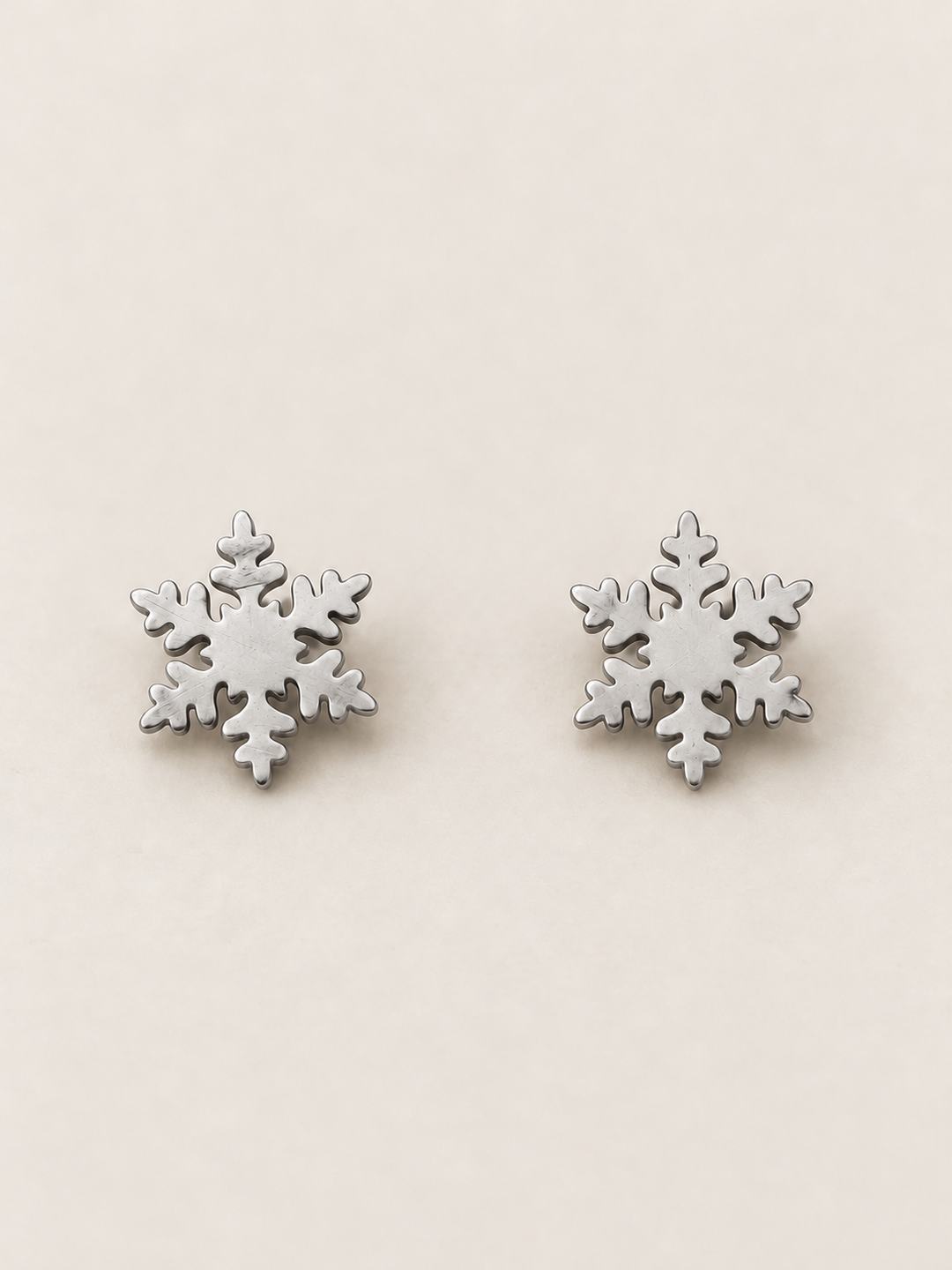 Silver Snowflake Stud Earrings shown on a warm neutral background