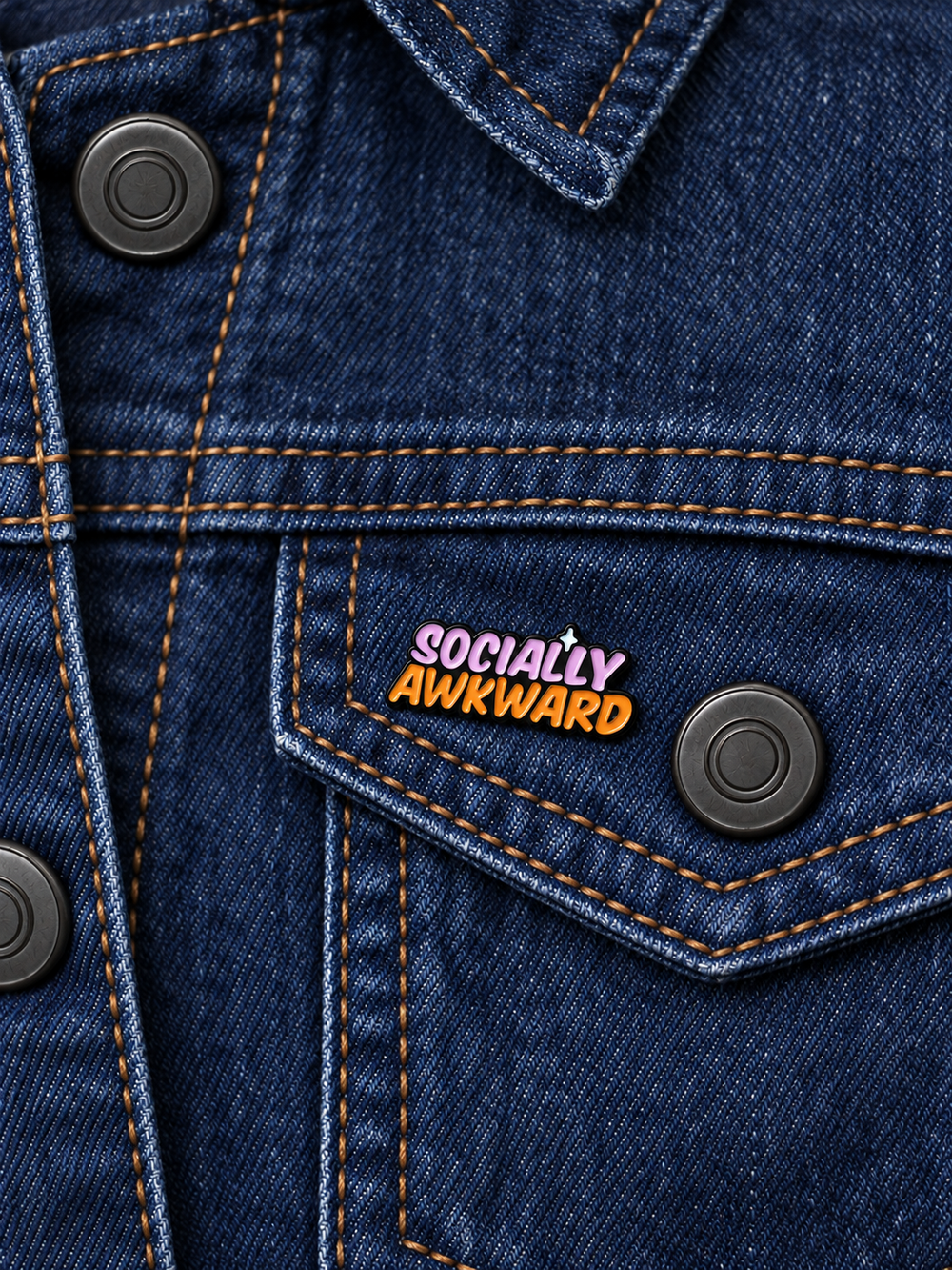 Socially Awkward Text Pin displayed on a dark indigo denim jacket beside a metal button