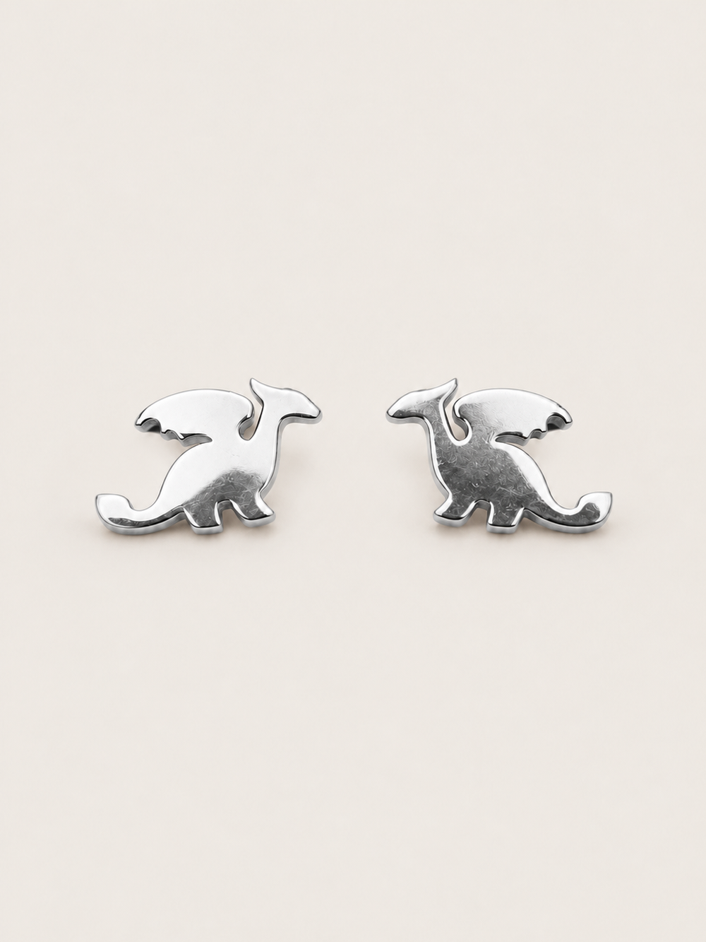 Silver main Stainless Steel Dragon Stud Earrings on a warm neutral background