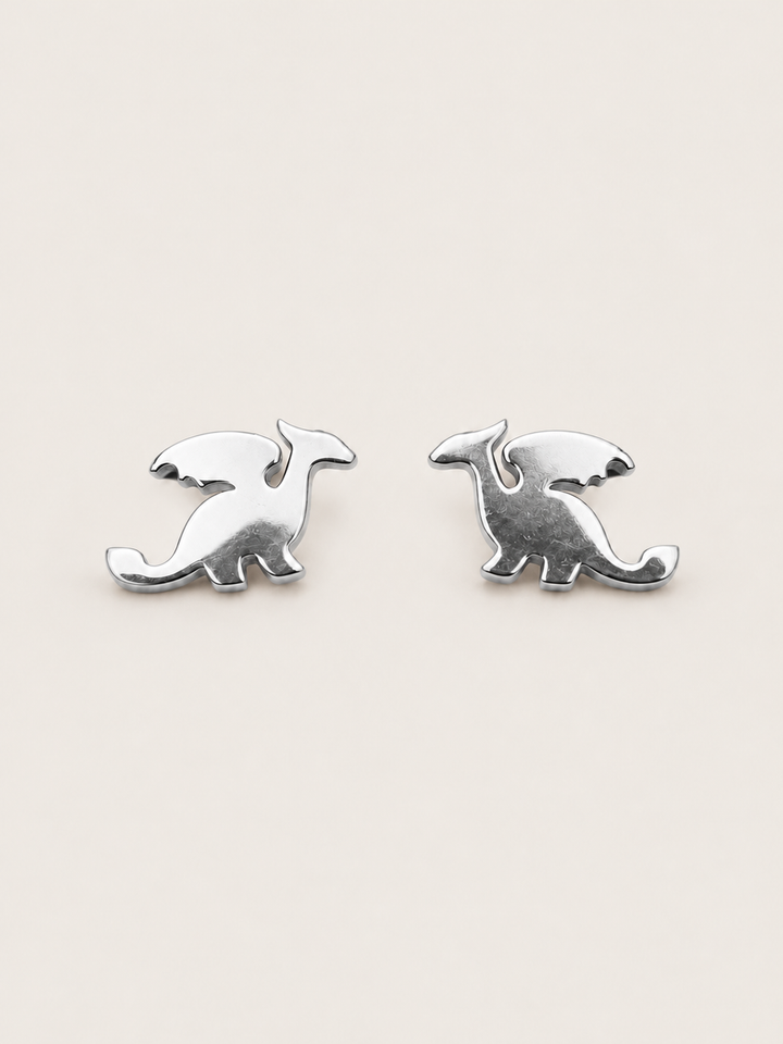 Silver main Stainless Steel Dragon Stud Earrings on a warm neutral background