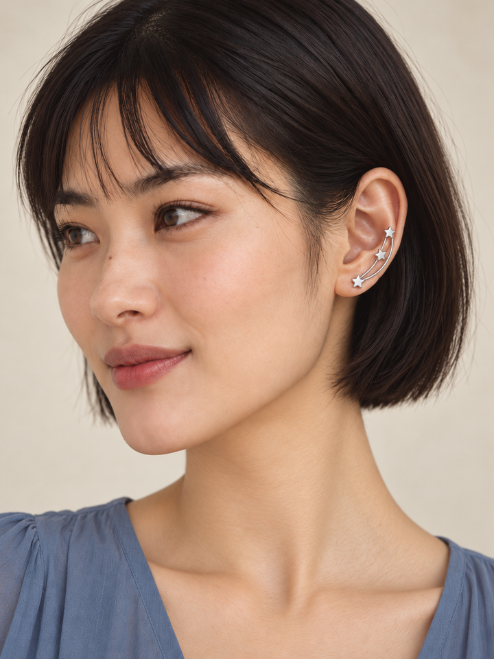 Silver Star Ear Crawler Earrings worn along the ear with the bottom star centered on the lobe