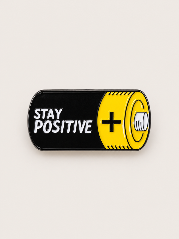 Stay Positive Battery Pin shown on a warm neutral background