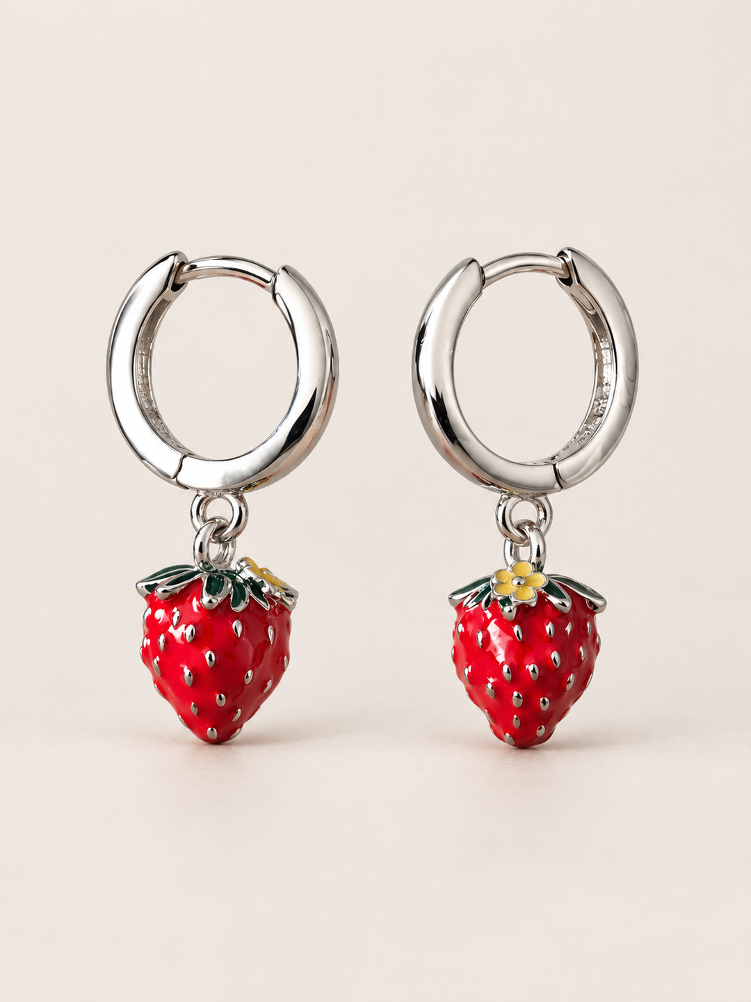 Strawberry Huggie Earrings shown on a warm neutral background