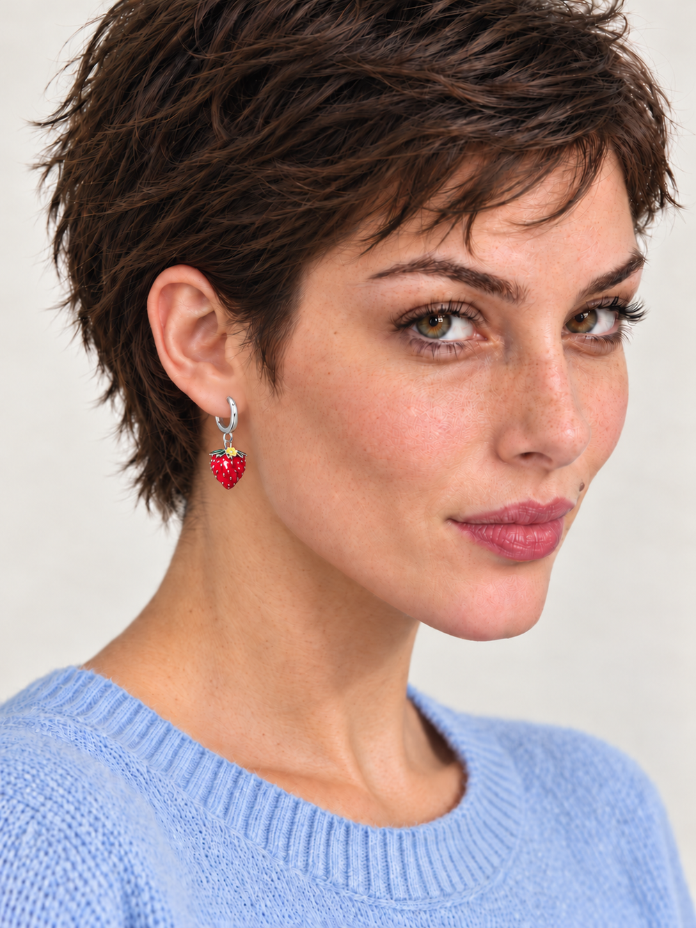 Strawberry Huggie Earrings worn on a model in a light blue sweater