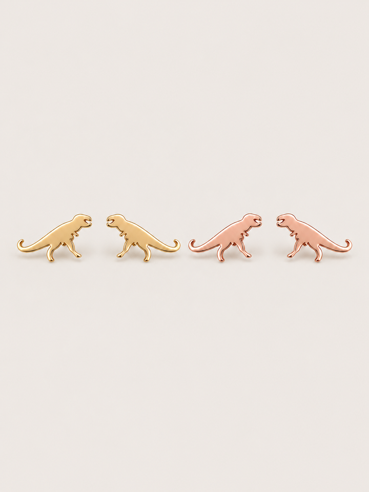 Gold and Rose Gold T-Rex Dinosaur Stud Earrings shown on a warm neutral background