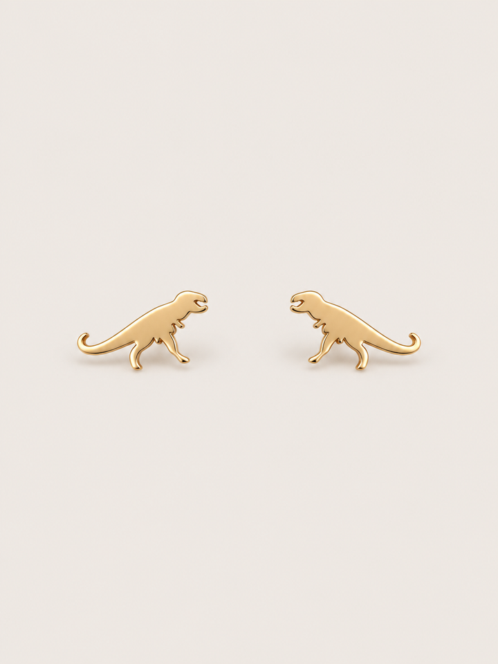 Gold T-Rex Dinosaur Stud Earrings shown on a warm neutral background