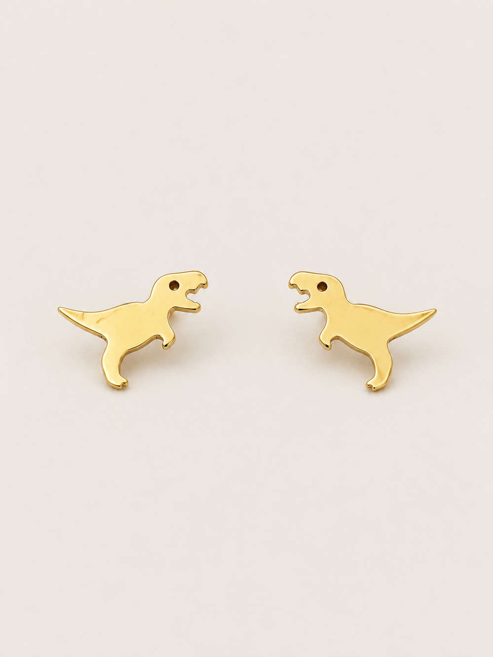 Gold T. Rex Stud Earrings shown on a warm neutral background