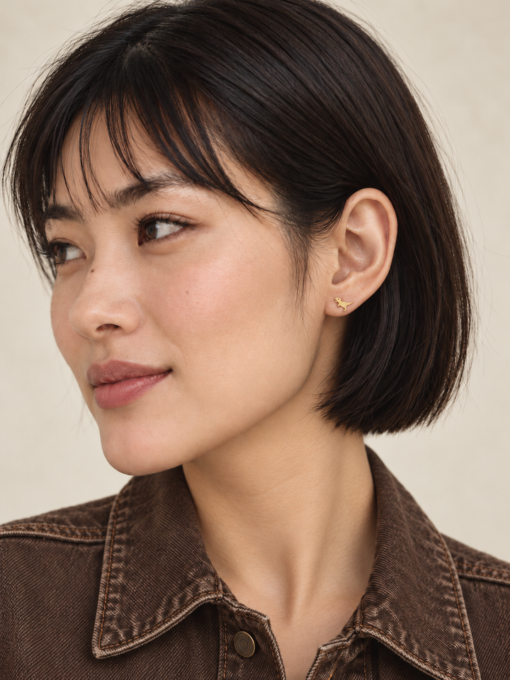 Gold T. Rex Stud Earring worn by a model in a brown denim jacket
