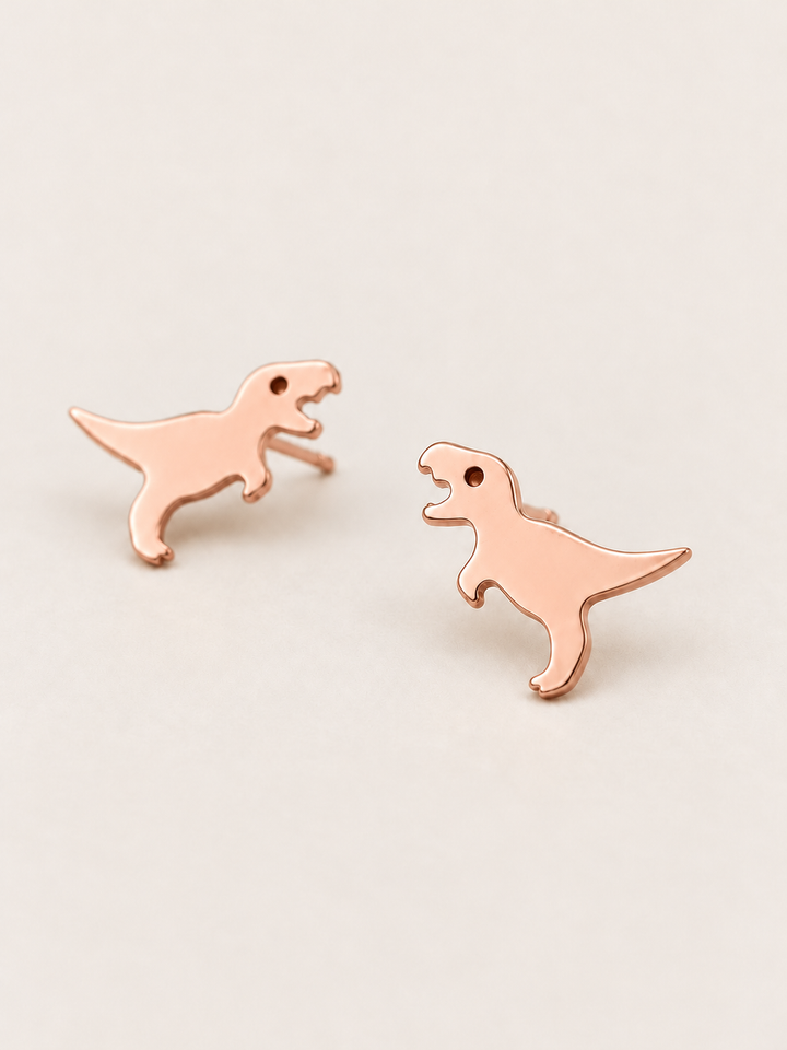 Rose Gold T. Rex Stud Earrings shown angled on a warm neutral background