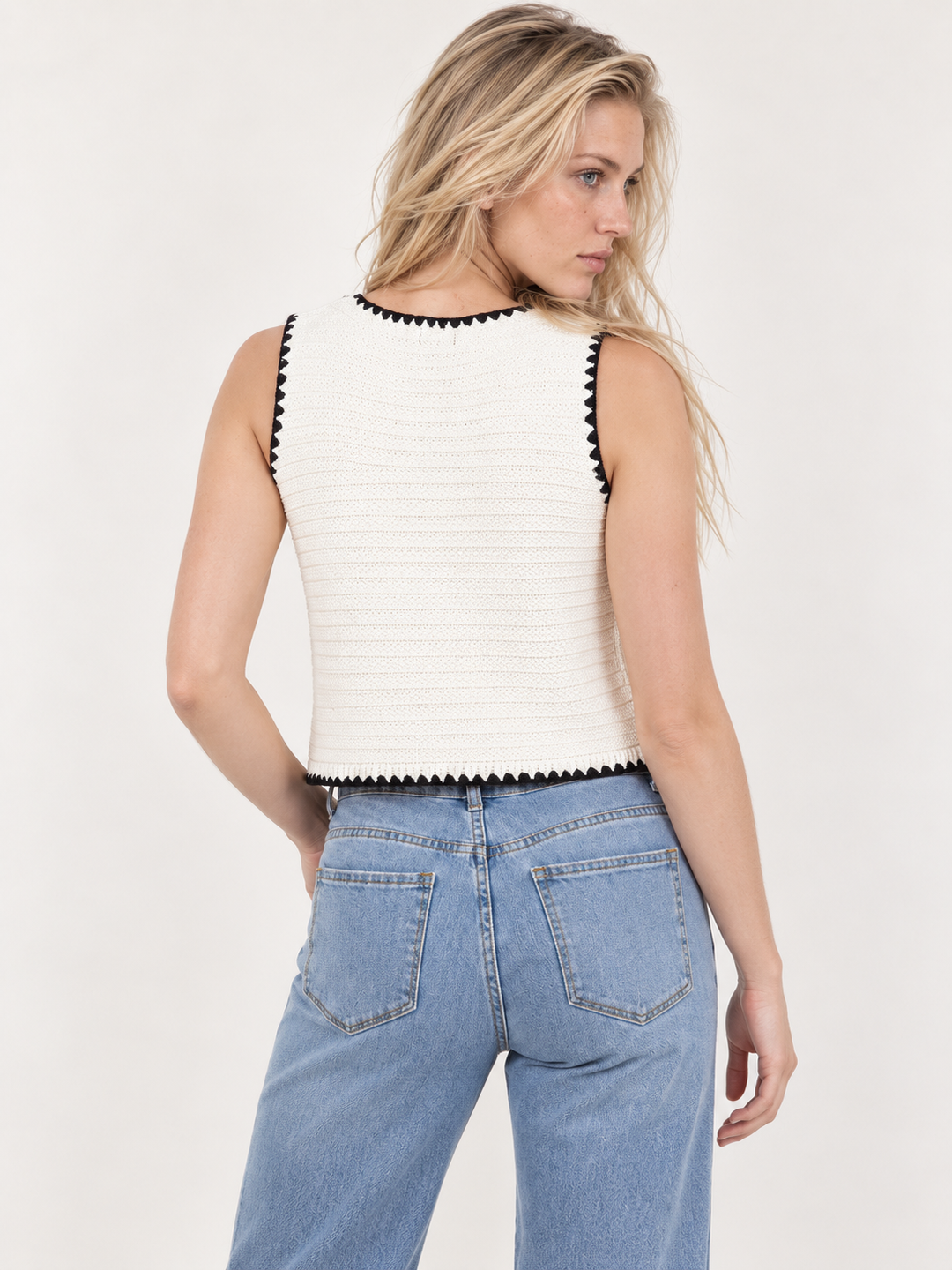 Model wearing textured knit vest in ivory, back view