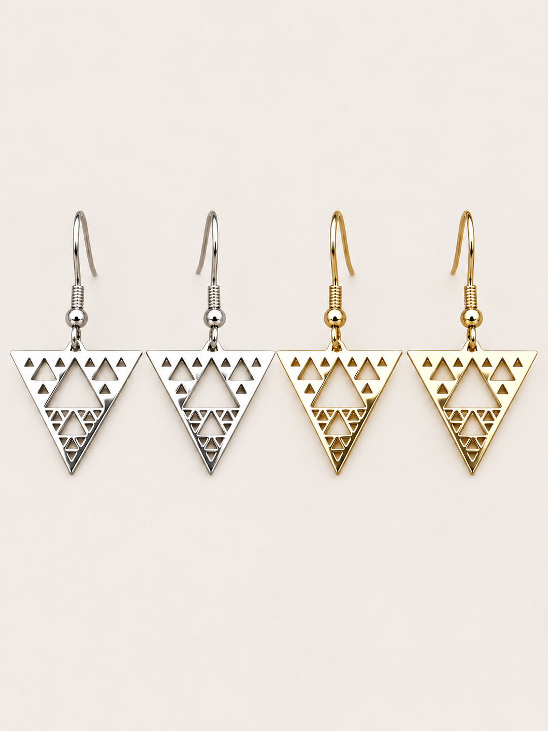 Triangle Cutout Drop Earrings in silver and gold shown on a warm neutral background