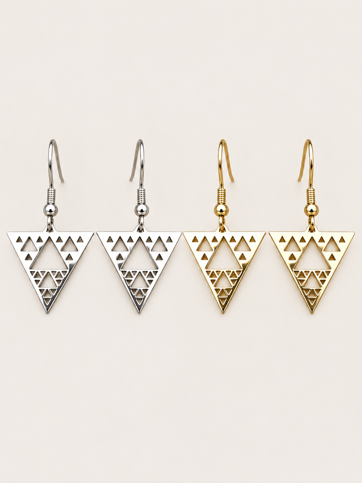 Triangle Cutout Drop Earrings in silver and gold shown on a warm neutral background