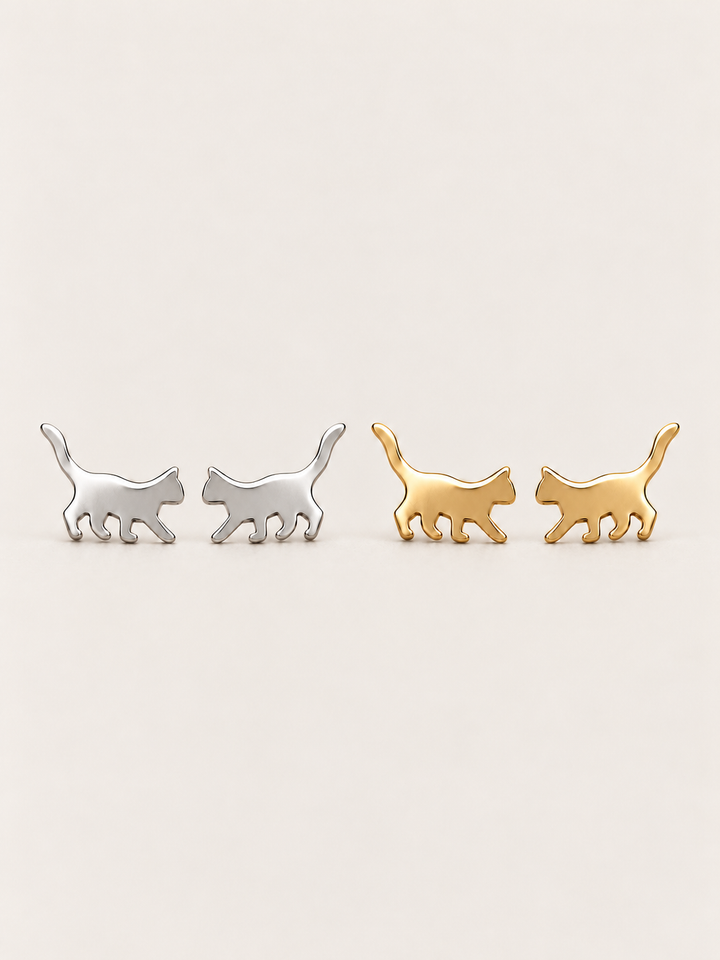 Walking Cat Stud Earrings in Silver and Gold shown on a warm neutral background