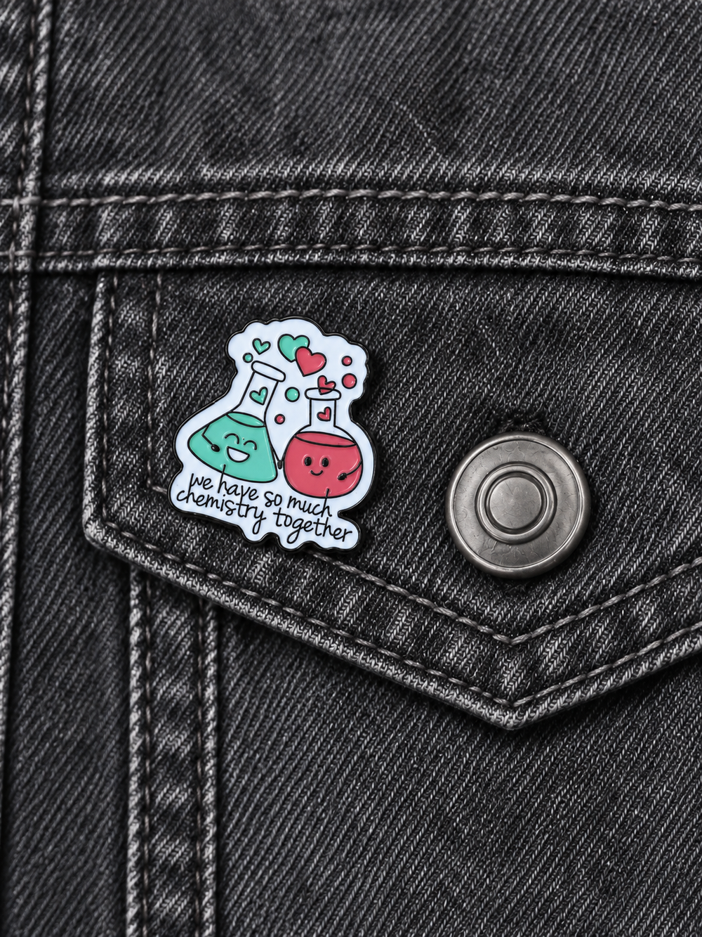 We Have So Much Chemistry Together Pin displayed on a charcoal denim jacket beside a metal button