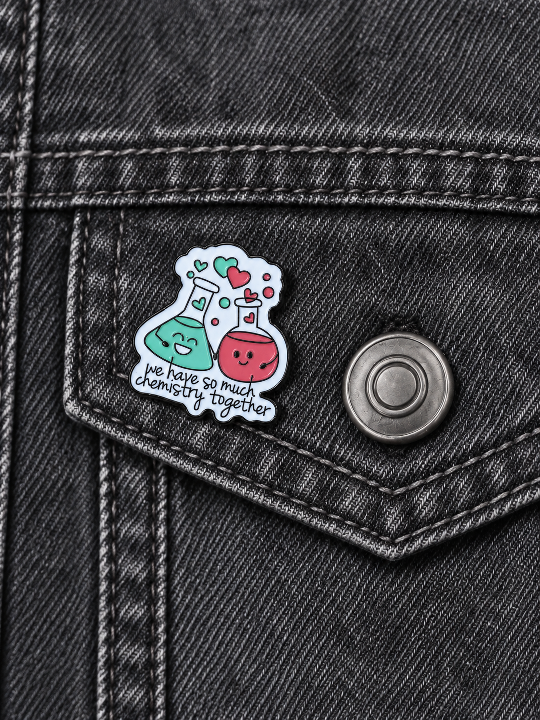 We Have So Much Chemistry Together Pin displayed on a charcoal denim jacket beside a metal button