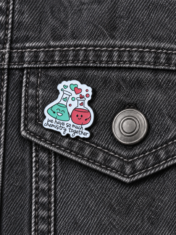 We Have So Much Chemistry Together Pin displayed on a charcoal denim jacket beside a metal button