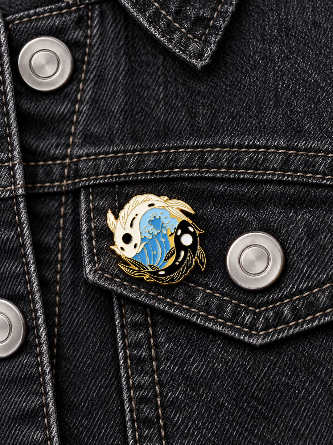 Yin Yang Koi Wave Pin displayed on black denim beside a brushed silver button