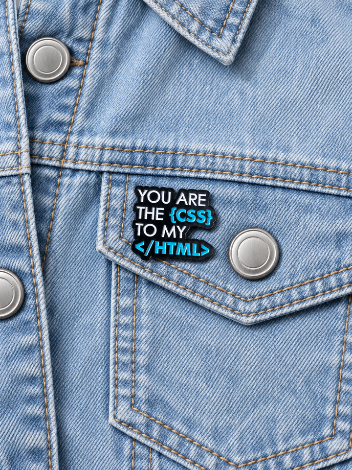 You Are the CSS to My HTML Pin displayed on a light-wash denim jacket beside a metal button