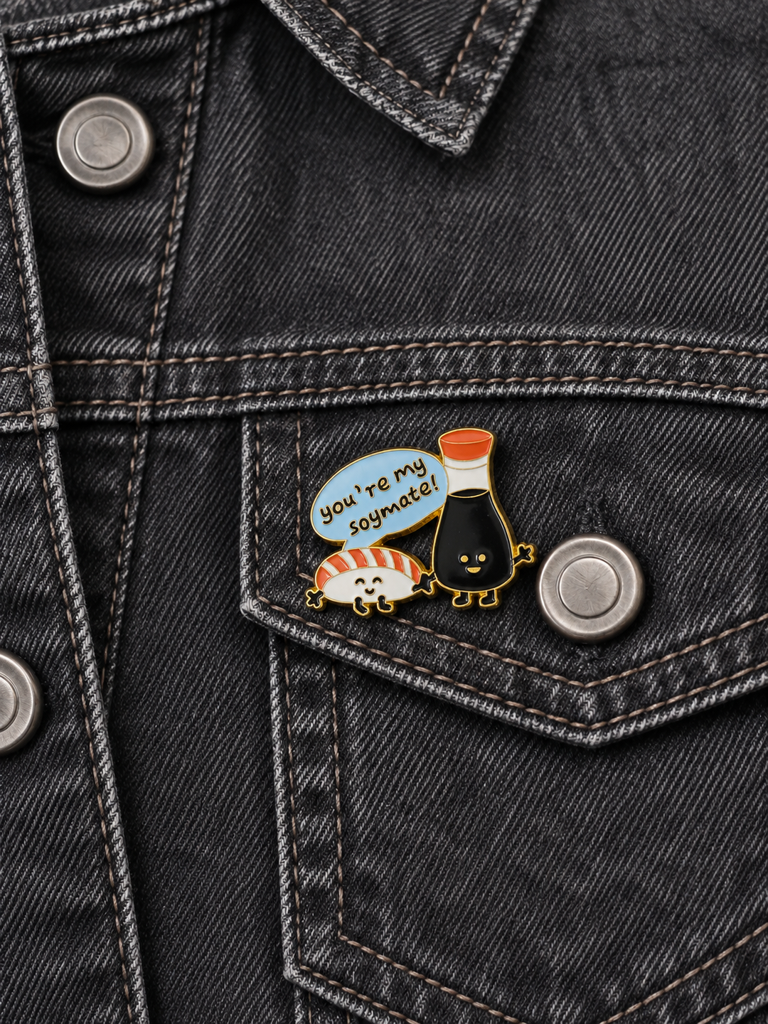 You're My Soymate Sushi Pin displayed on a charcoal denim jacket beside a metal button